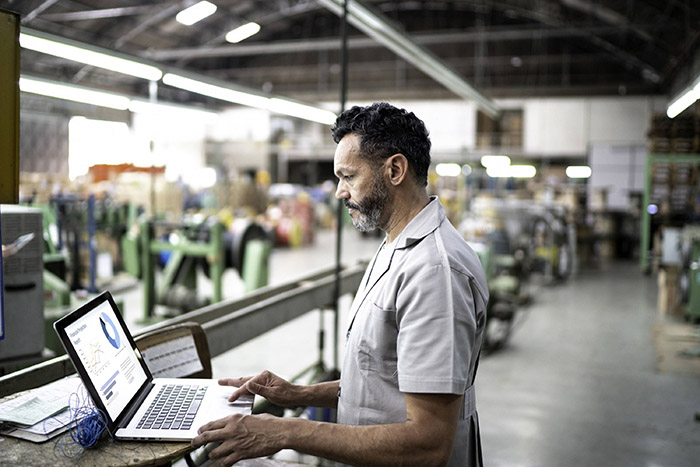 processo de produção - homem utilizando notebook para avaliar informações e estatísticas da produção de uma fábrica